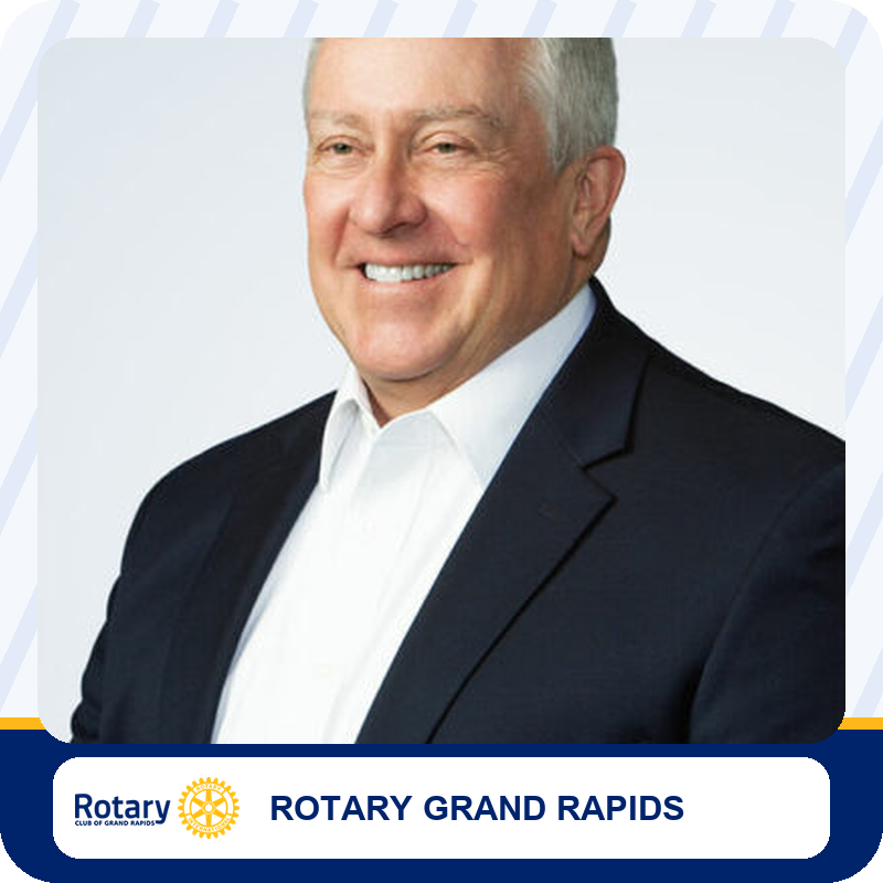 bruce-young Smiling man in a dark suit and white shirt; portrait used for Rotary Grand Rapids branding.