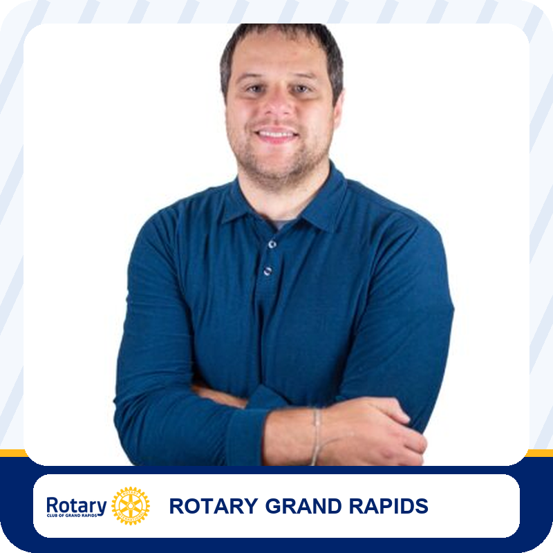 Portrait of a man in a blue polo shirt with arms crossed, representing Rotary Club of Grand Rapids.