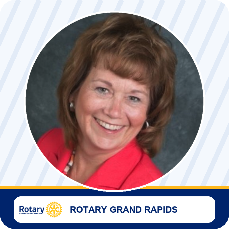 Portrait of a smiling woman in a red blazer, used for Rotary Grand Rapids branding with the Rotary logo at the bottom.